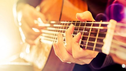 A tutor playing a guitor